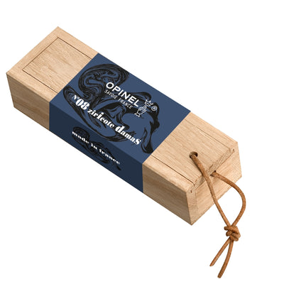 A wooden Opinel oak pencil case with a navy blue paper band featuring black graphics and text, complete with a brown leather cord, shown on a plain white background.